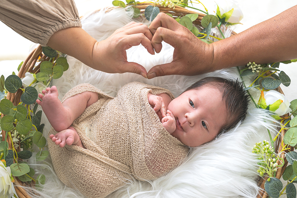 ニューボーンフォトの様子。パパとママでハートを作りました。